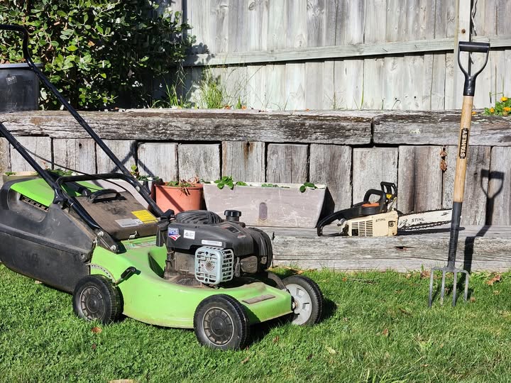 Blaze Mowing gear — petrol mower, chainsaw and garden fork in a Christchurch backyard