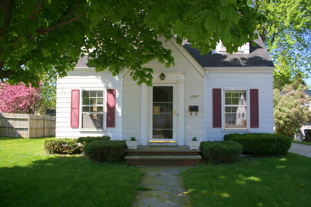Suburban home with neatly trimmed hedges and mowed lawn